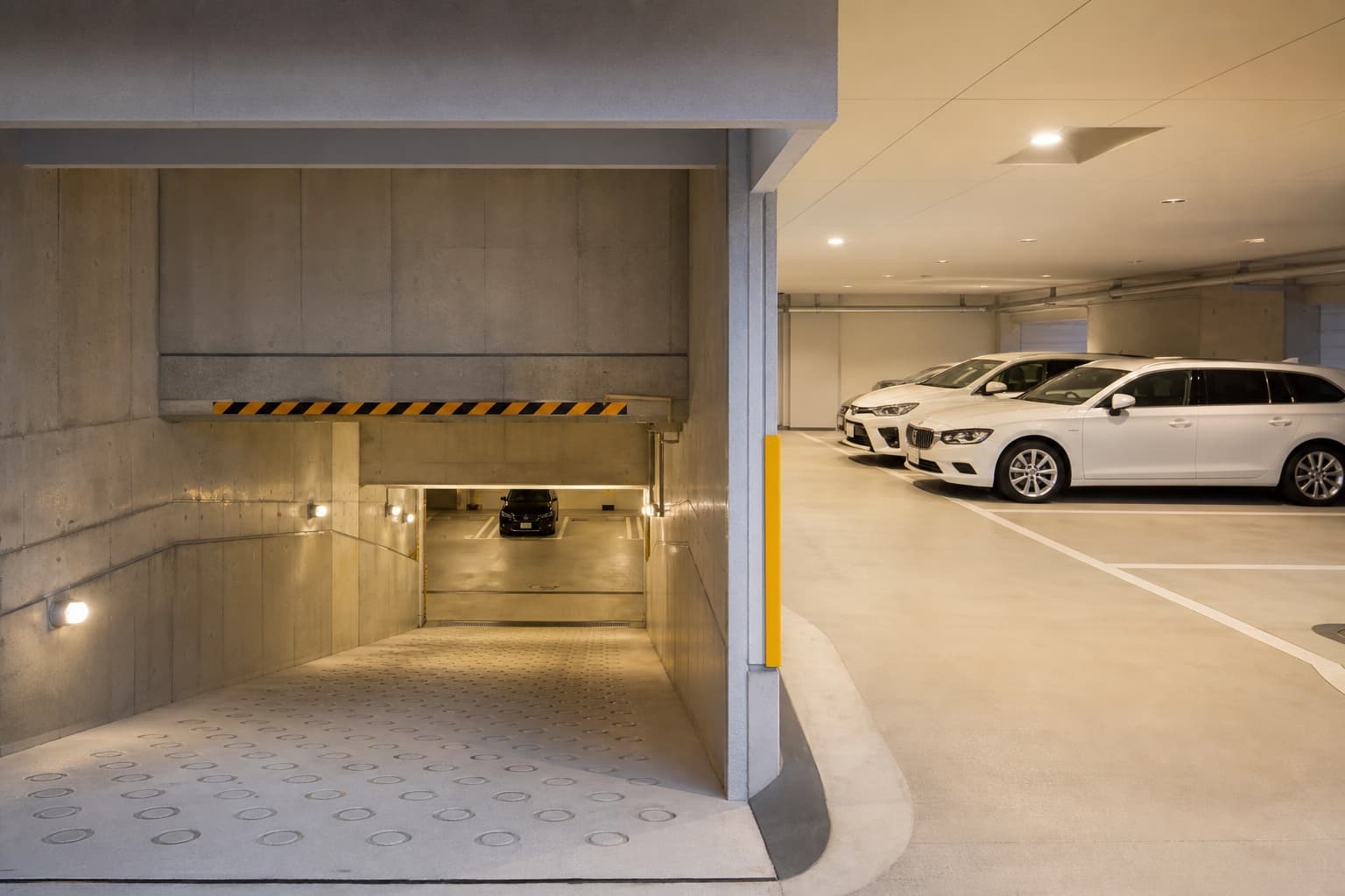 地下へ下るスロープとマンションの地下駐車場